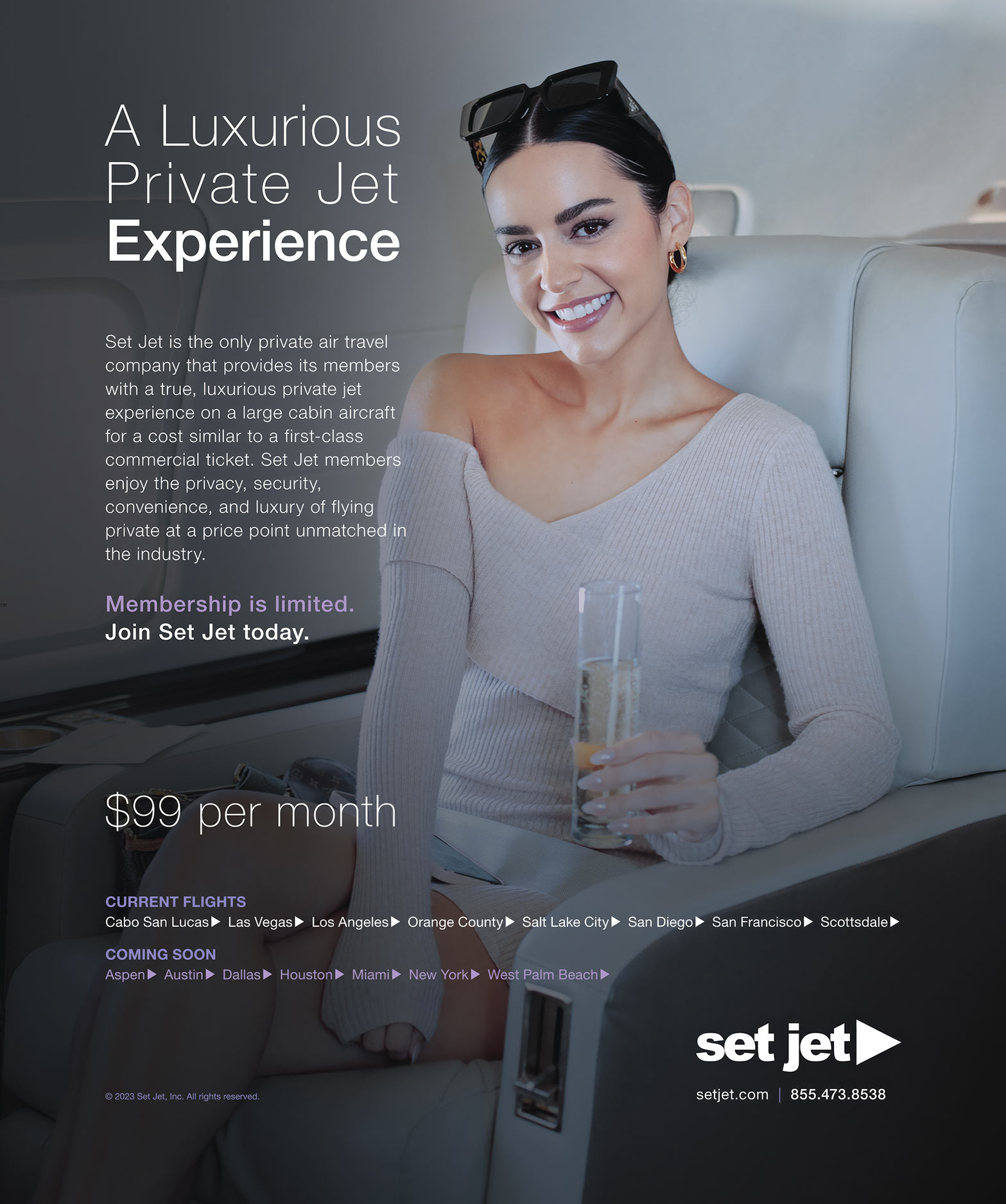 A smiling woman sitting in a private jet holding a glass of champagne.